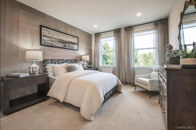 a bedroom with a large bed and windows