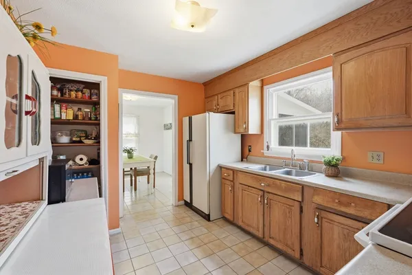 a kitchen that has a sink a refrigerator and window