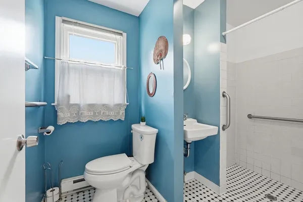 a white toilet sitting next to a bathroom sink and a shower