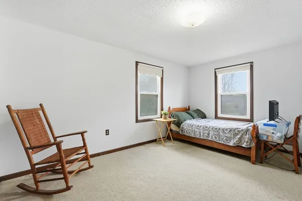 a bedroom with a bed chair and window