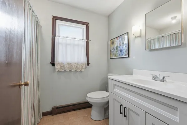 a bathroom with a toilet sink and mirror