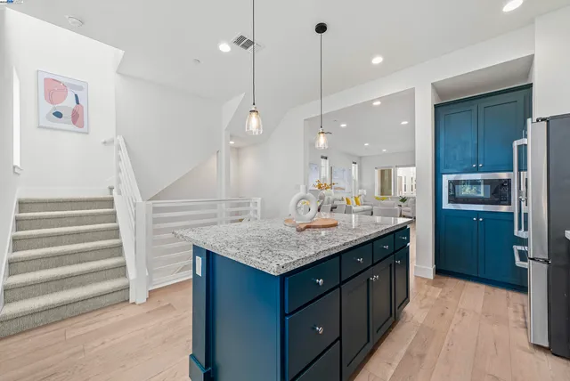 a kitchen with kitchen island a sink stainless steel appliances and cabinets