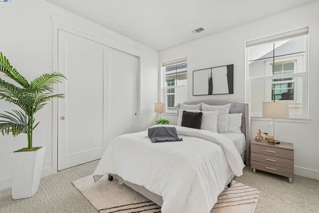 a bedroom with a bed and a potted plant