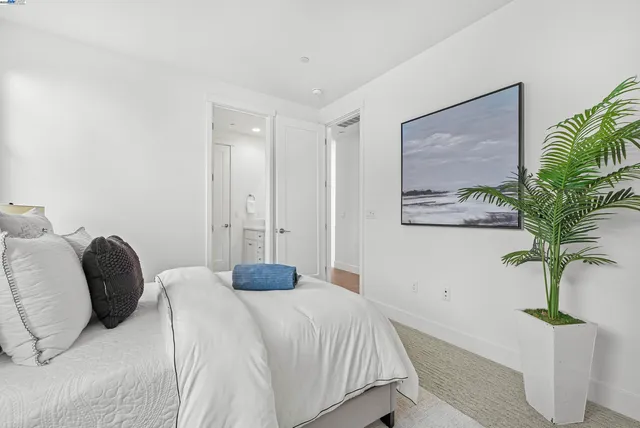 a bedroom with a bed and a potted plant