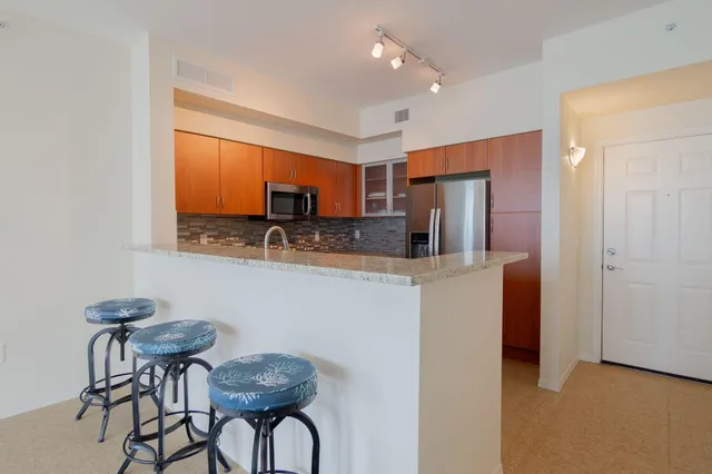 a kitchen with stainless steel appliances granite countertop a refrigerator and a stove top oven