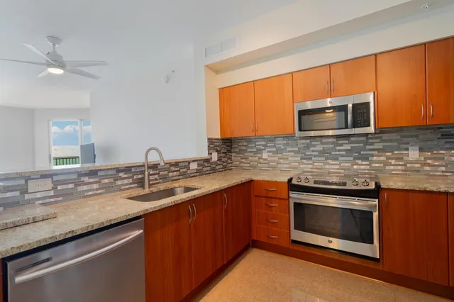 a kitchen with stainless steel appliances granite countertop a sink stove and microwave