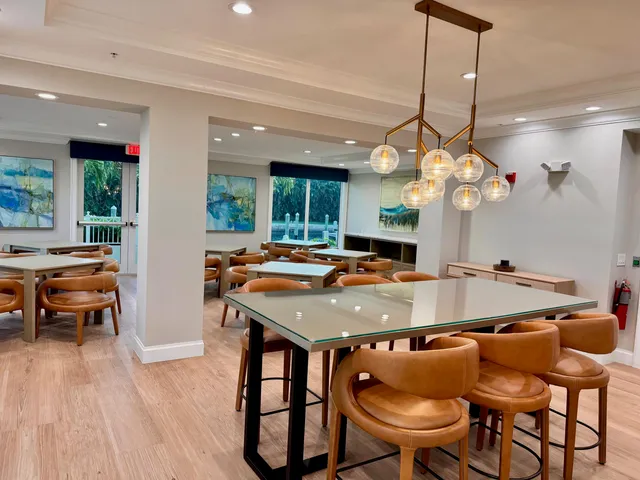 a front view of multi story residential apartment building with yard and potted plants