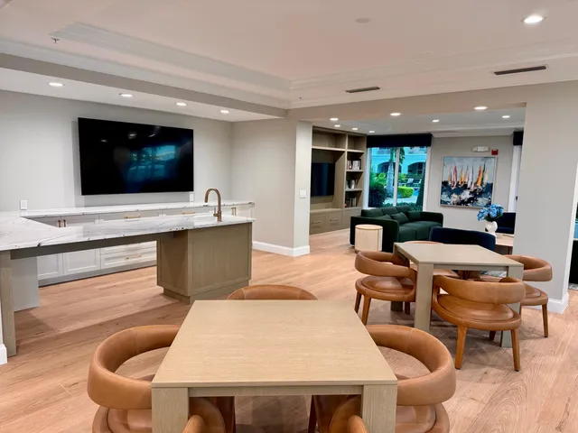 a view of a dining room and livingroom with furniture wooden floor a chandelier