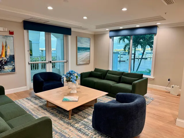 a living room with furniture kitchen view and a large window