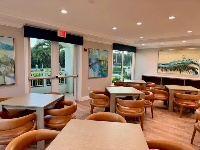 a living room with furniture potted plant wooden floor and a large window