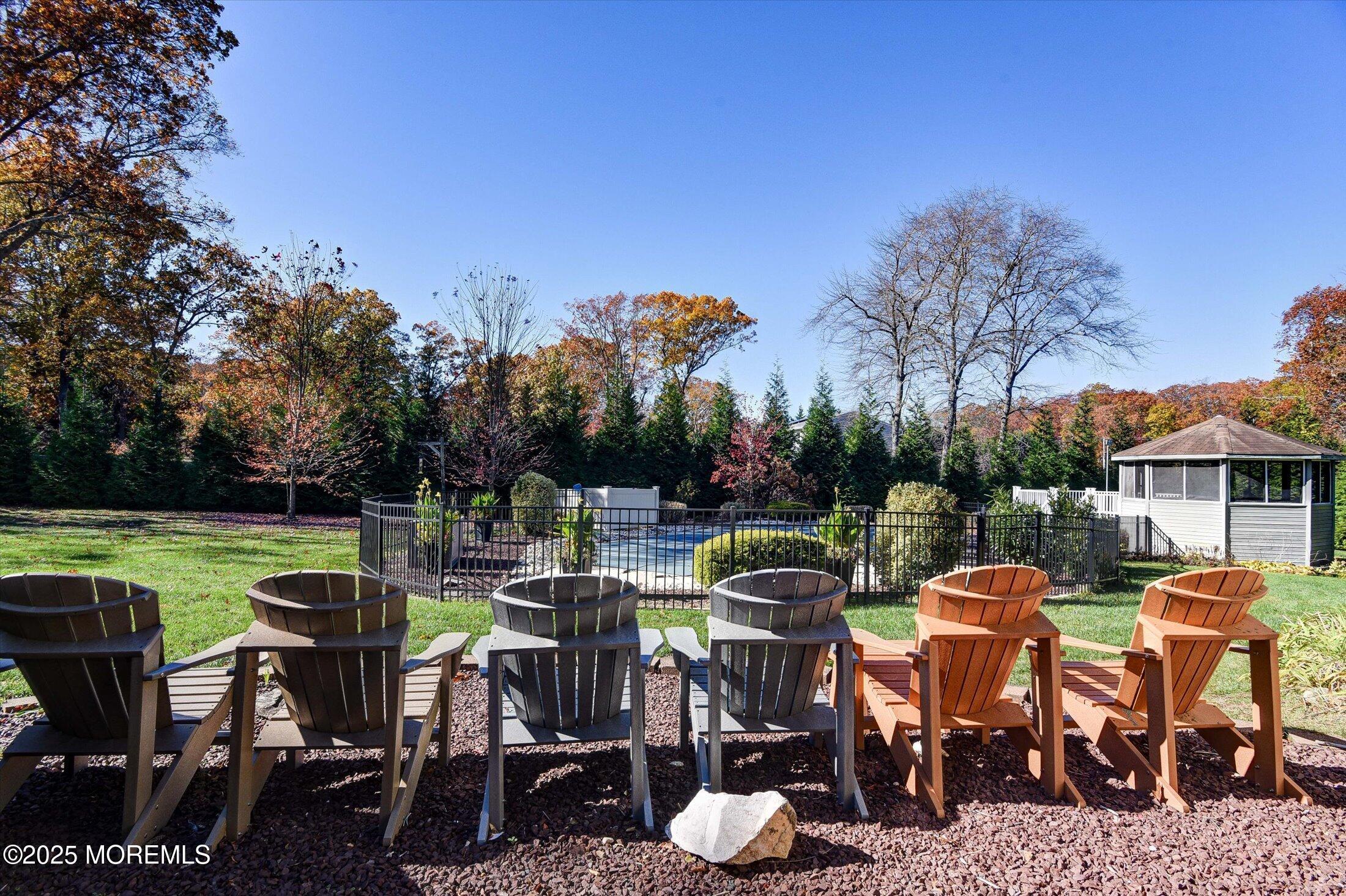 2 Lyndon Lane Howell, NJ 07731 - Photo 42 of 51 a view of a patio with table and chairs under an umbrella with large trees