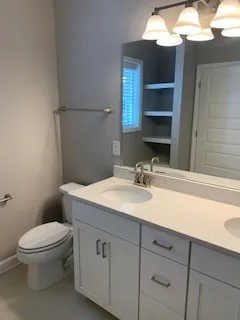 a bathroom with a toilet sink and mirror
