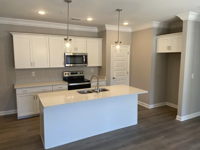 a kitchen with kitchen island a stove a refrigerator and a sink