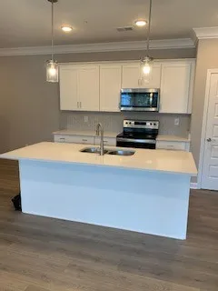 a kitchen with kitchen island a stove a sink and a microwave