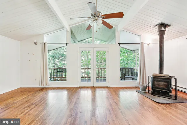 a view of a livingroom with wooden floor and a ceiling fan