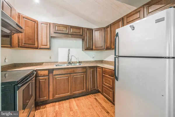 a kitchen with stainless steel appliances granite countertop a refrigerator a sink and a stove