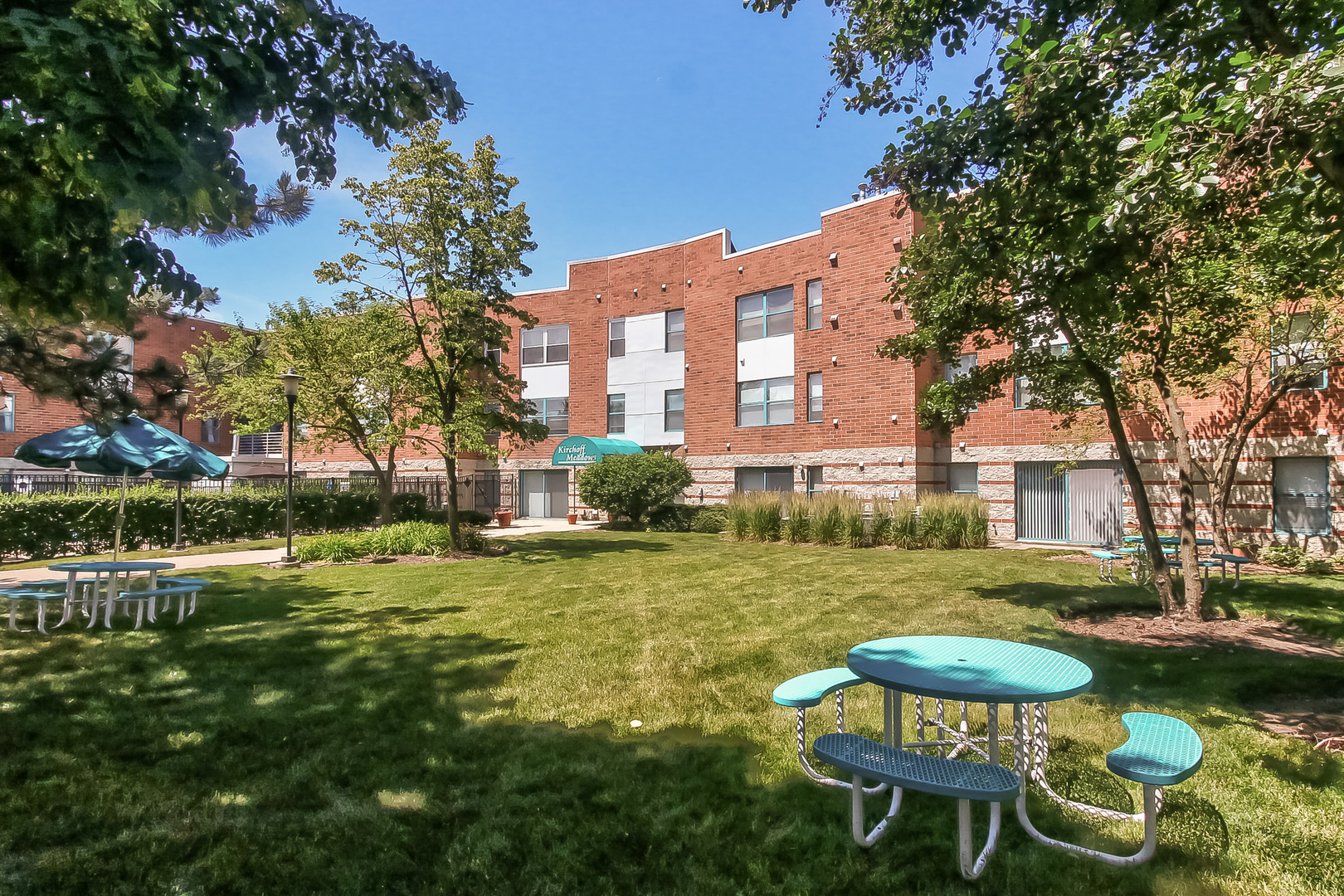 3255 Kirchoff Road, Unit 208 Rolling Meadows, IL 60008 - Photo 1 of 21 a view of a white house with a yard table and chairs