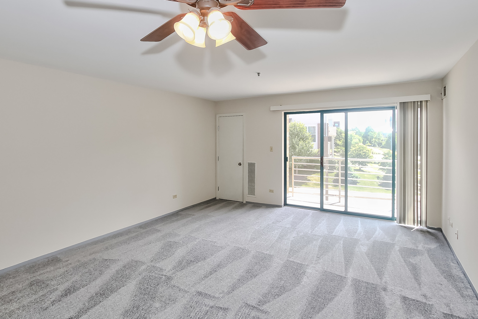 3255 Kirchoff Road, Unit 208 Rolling Meadows, IL 60008 - Photo 5 of 21 an empty room with chandelier fan and windows