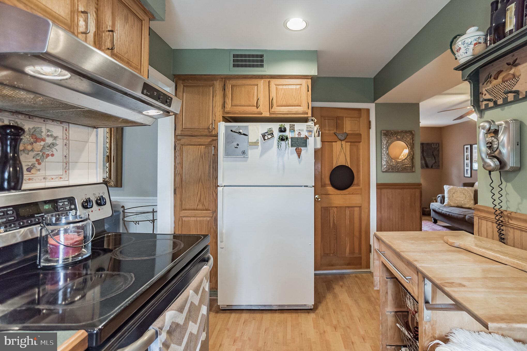 214 Claremont Road Springfield, PA 19064 - Photo 11 of 30 a kitchen with stainless steel appliances granite countertop a refrigerator a stove and a sink with wooden floor