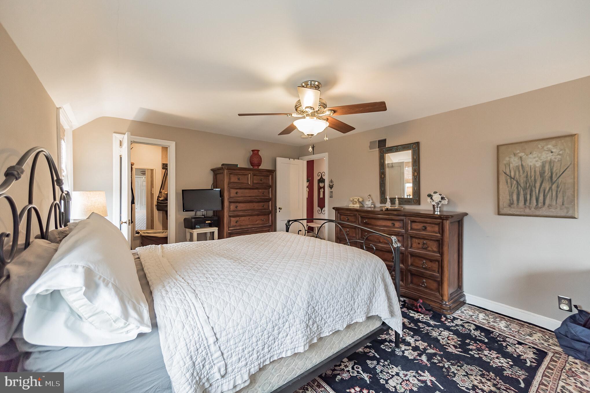 214 Claremont Road Springfield, PA 19064 - Photo 21 of 30 a spacious bedroom with a bed a dresser and potted plants