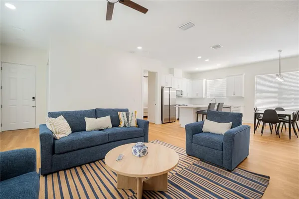 a living room with furniture kitchen view and a table