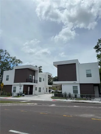 a front view of a house with a garden and parking