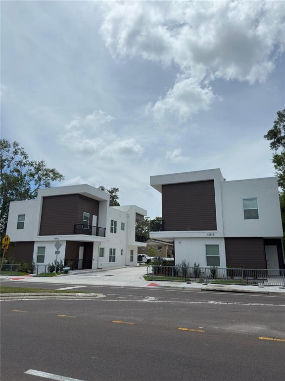 13614 North 22nd Street Tampa, FL 33613 - Photo 3 of 30 a front view of a house with a garden and parking