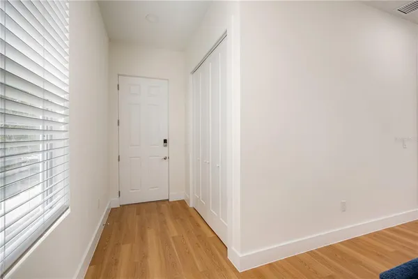 a view of a room with wooden floor and a window