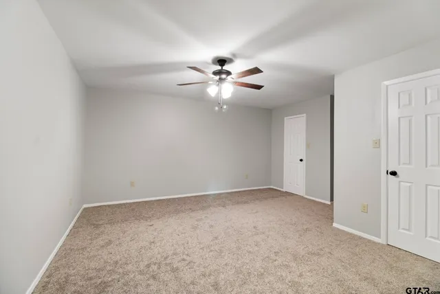 an empty room with fan and a ceiling fan