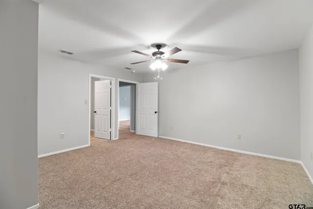 a view of an empty room with a ceiling fan
