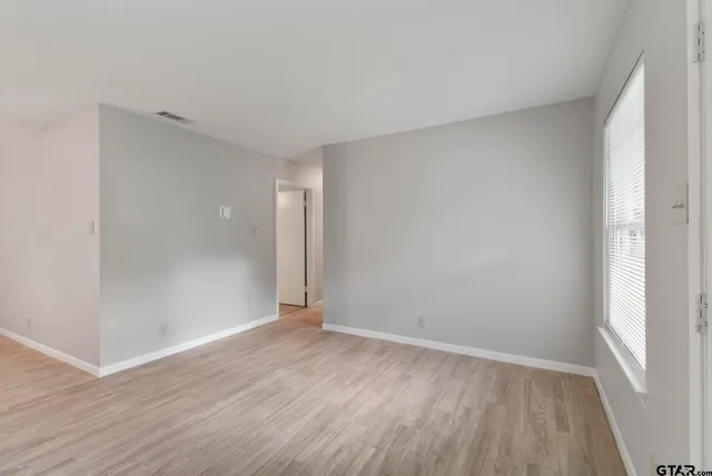 a view of an empty room with wooden floor