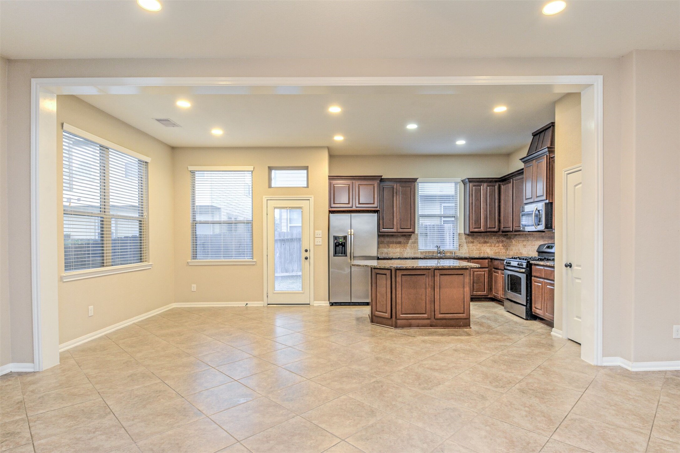 19 Cheswood Manor Court The Woodlands, TX 77382 - Photo 13 of 37 a large kitchen with stainless steel appliances kitchen island granite countertop a large counter top and a stove top oven
