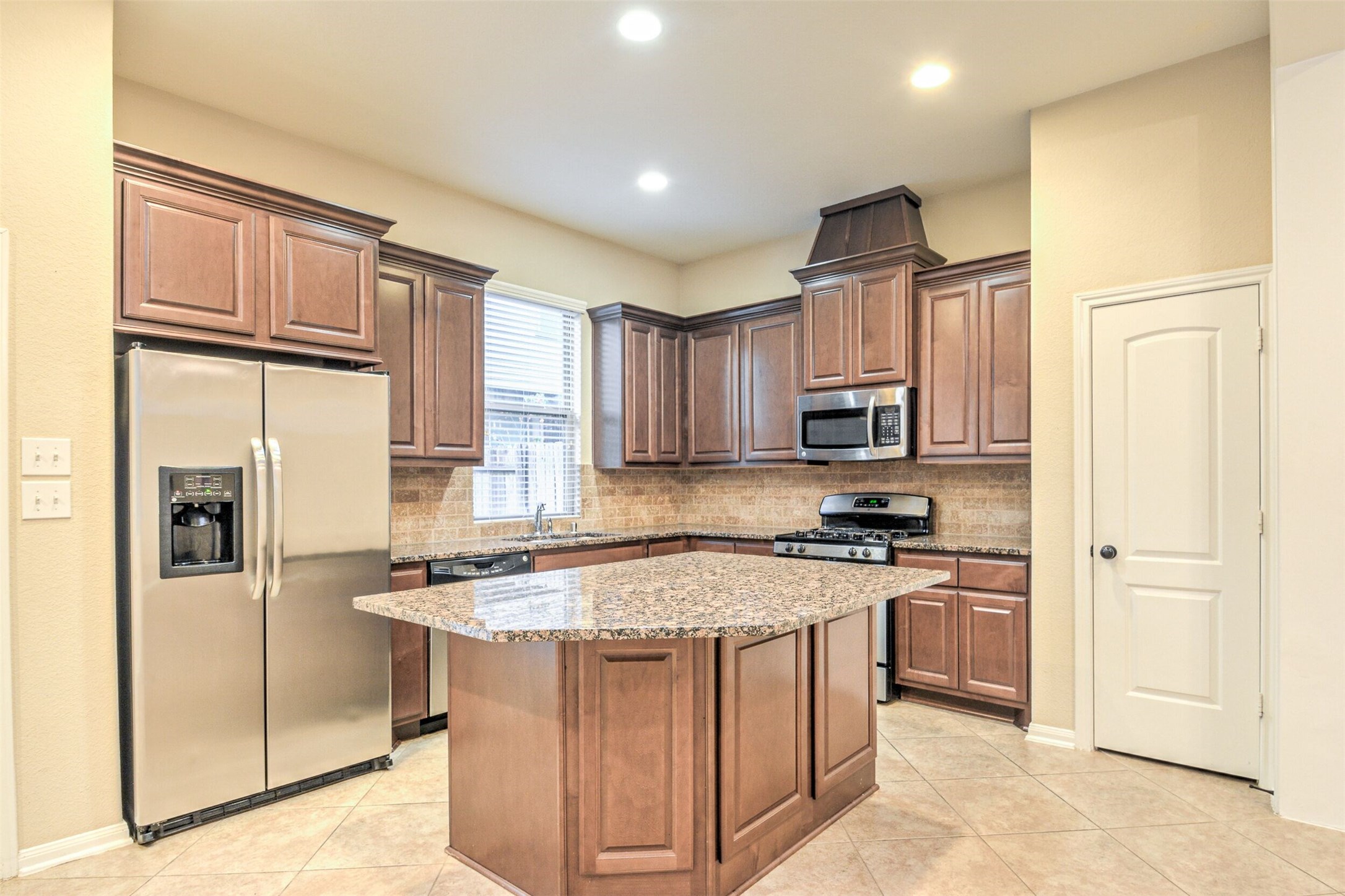19 Cheswood Manor Court The Woodlands, TX 77382 - Photo 16 of 37 a kitchen with stainless steel appliances granite countertop a refrigerator stove and sink