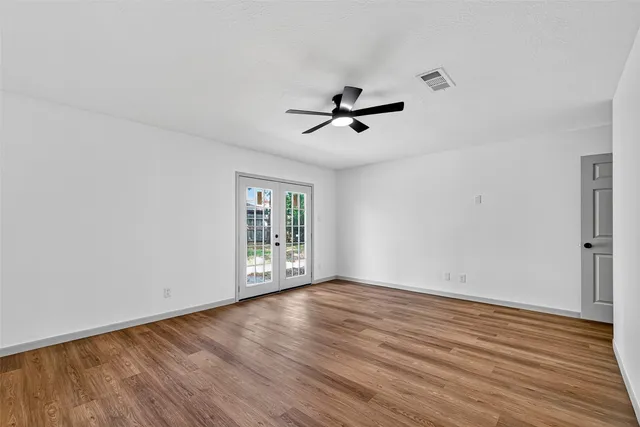 wooden floor in an empty room with a window