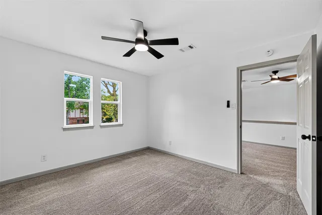 a view of a livingroom with a window and a ceiling fan