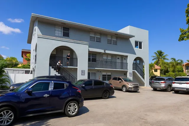 a view of a house with a yard and potted plants