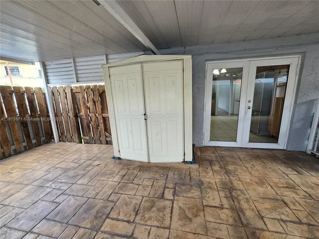 a view of a livingroom with a chandelier fan and windows