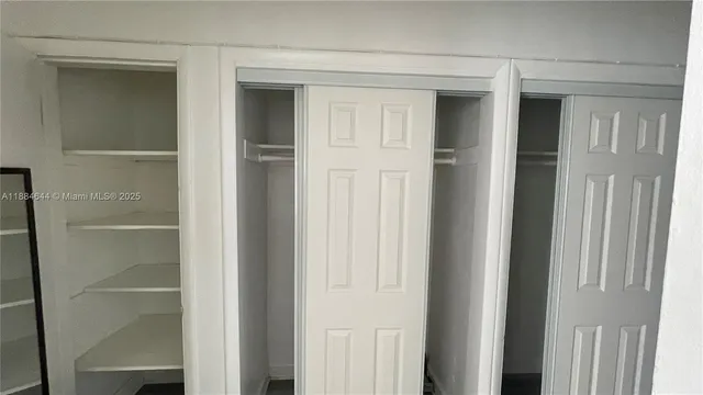 a view of walk in closet with empty racks