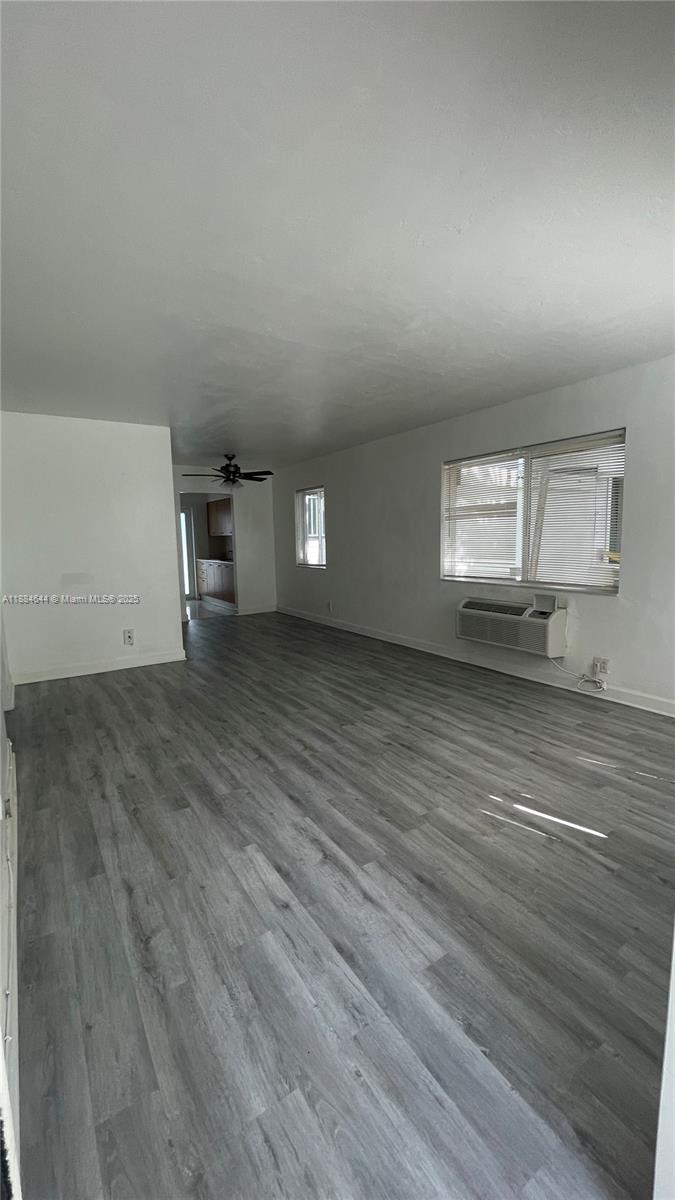 320 86th Street, Unit 3 Miami Beach, FL 33141 - Photo 3 of 13 an empty room with wooden floor and windows