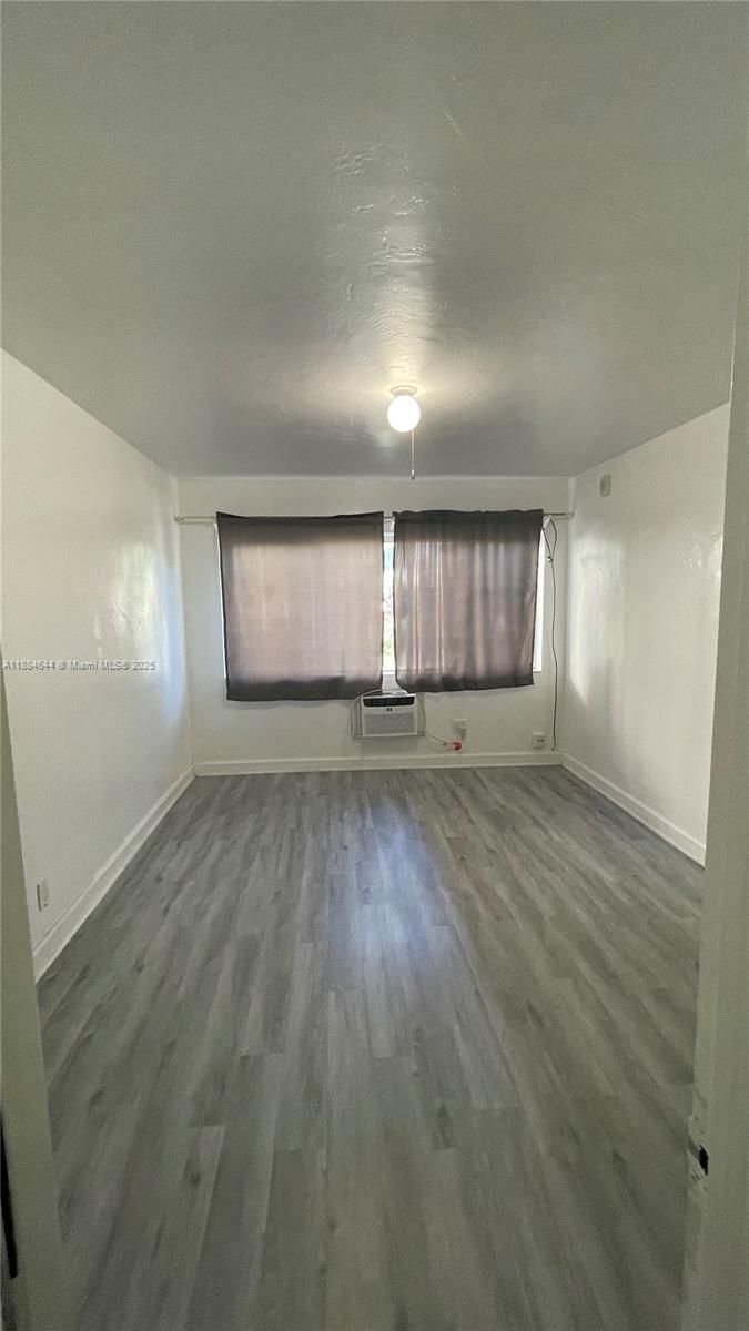 320 86th Street, Unit 3 Miami Beach, FL 33141 - Photo 9 of 13 an empty room with wooden floor and windows