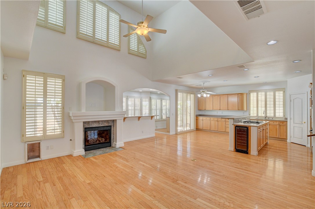 4354 Tall Tree Street Las Vegas, NV 89147 - Photo 14 of 67 This airy open-concept space features warm hardwood flooring, a fireplace, and an inviting kitchen island.