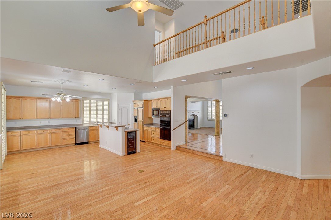 4354 Tall Tree Street Las Vegas, NV 89147 - Photo 15 of 67 This expansive open-concept living space features warm wood flooring and abundant natural light.