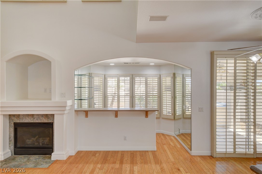 4354 Tall Tree Street Las Vegas, NV 89147 - Photo 17 of 67 This bright living space features warm wood floors and a charming fireplace, perfect for gathering.