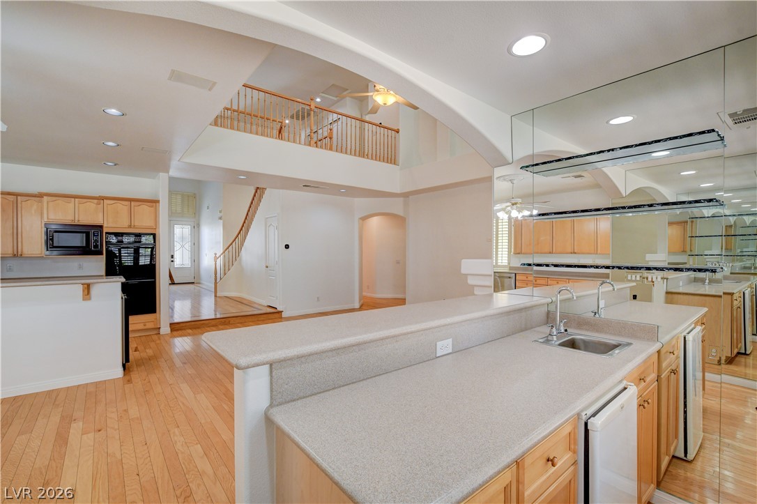 4354 Tall Tree Street Las Vegas, NV 89147 - Photo 21 of 67 An inviting open-concept living space features a functional kitchen island and warm wood flooring.