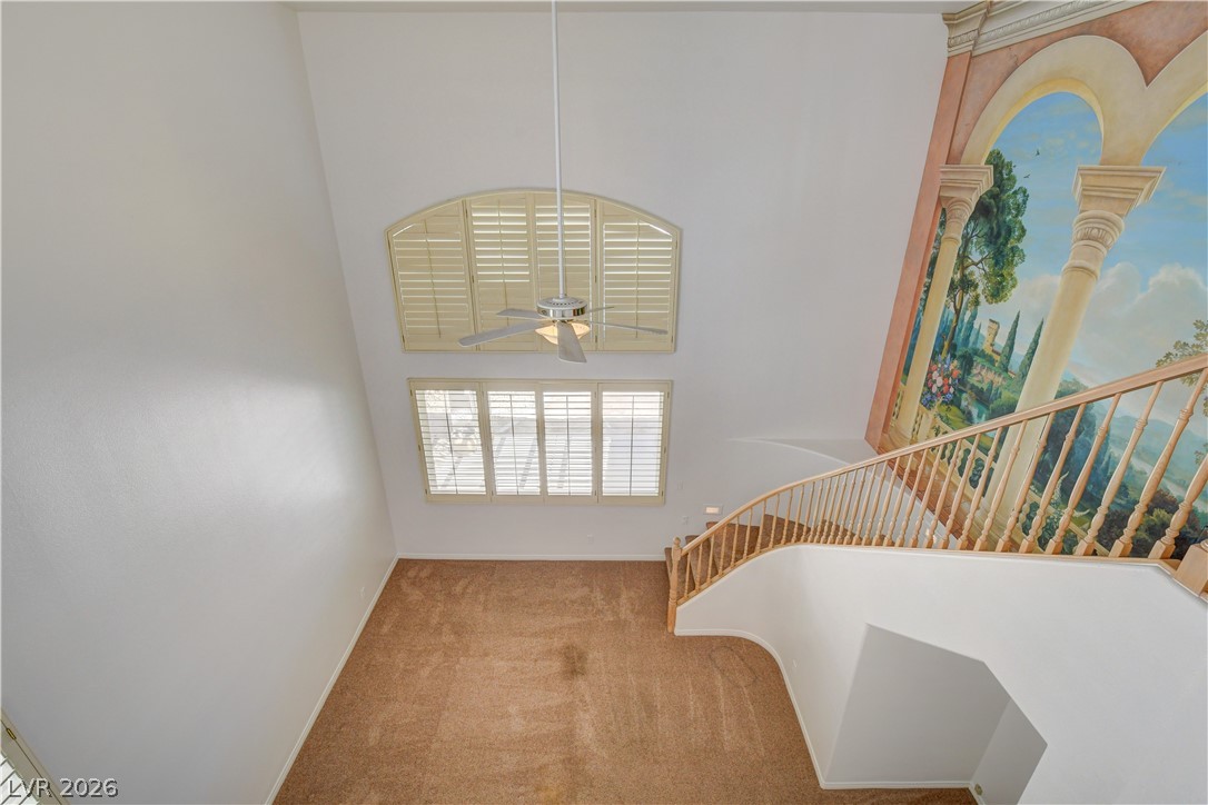 4354 Tall Tree Street Las Vegas, NV 89147 - Photo 32 of 67 This living space features soaring ceilings and an elegant winding staircase, creating an airy and grand atmosphere.