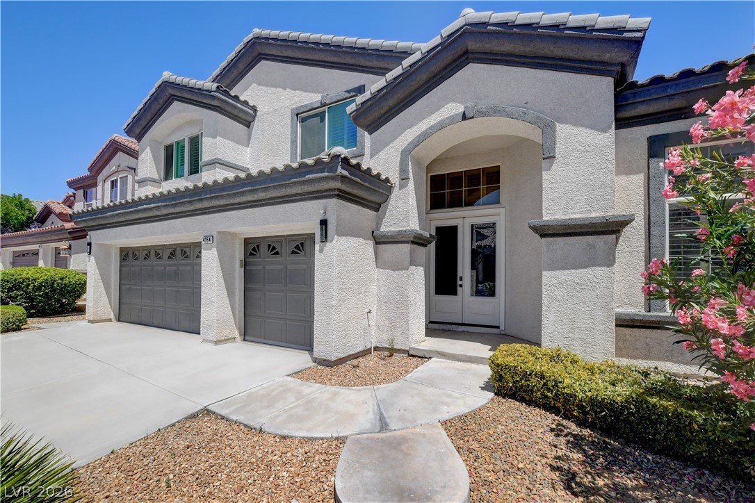 4354 Tall Tree Street Las Vegas, NV 89147 - Photo 4 of 67 This residence features a grand entrance with a concrete driveway and an attached two-car garage.