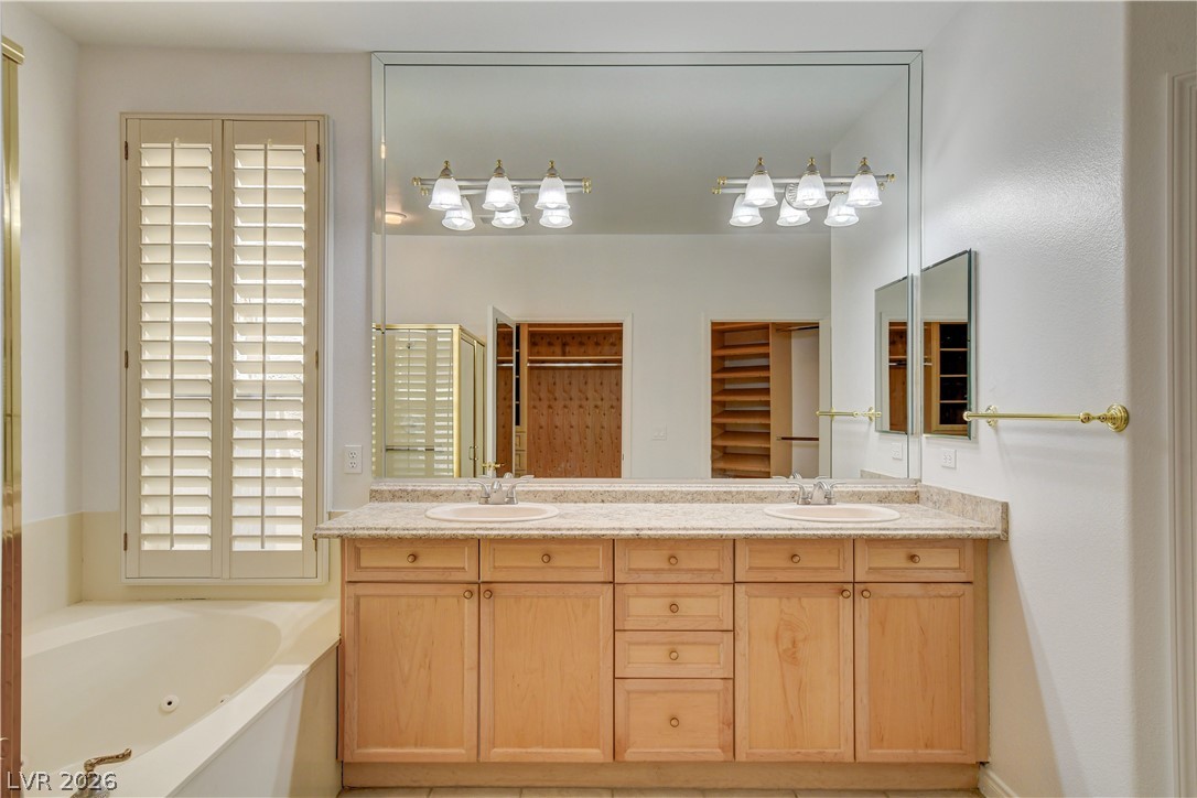 4354 Tall Tree Street Las Vegas, NV 89147 - Photo 40 of 67 This bathroom features a double vanity and soaking tub, offering both comfort and practicality.