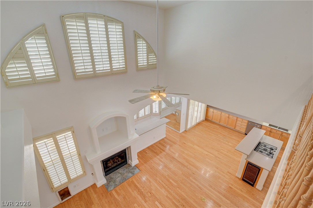 4354 Tall Tree Street Las Vegas, NV 89147 - Photo 41 of 67 This living area features high ceilings, a fireplace, and hardwood flooring.