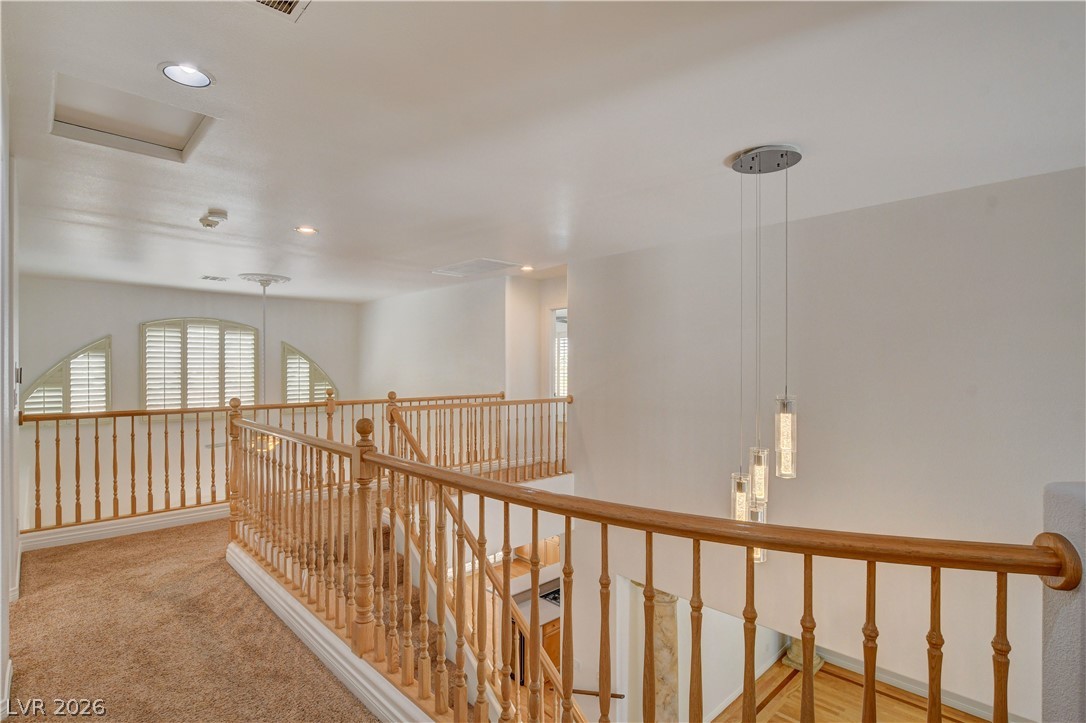 4354 Tall Tree Street Las Vegas, NV 89147 - Photo 45 of 67 This bright hallway showcases a grand staircase with elegant wooden railings.