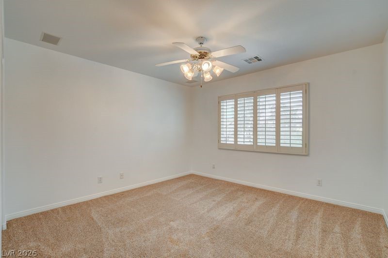 4354 Tall Tree Street Las Vegas, NV 89147 - Photo 46 of 67 This bright bedroom features a ceiling fan and elegant plantation shutters, offering comfort and style.